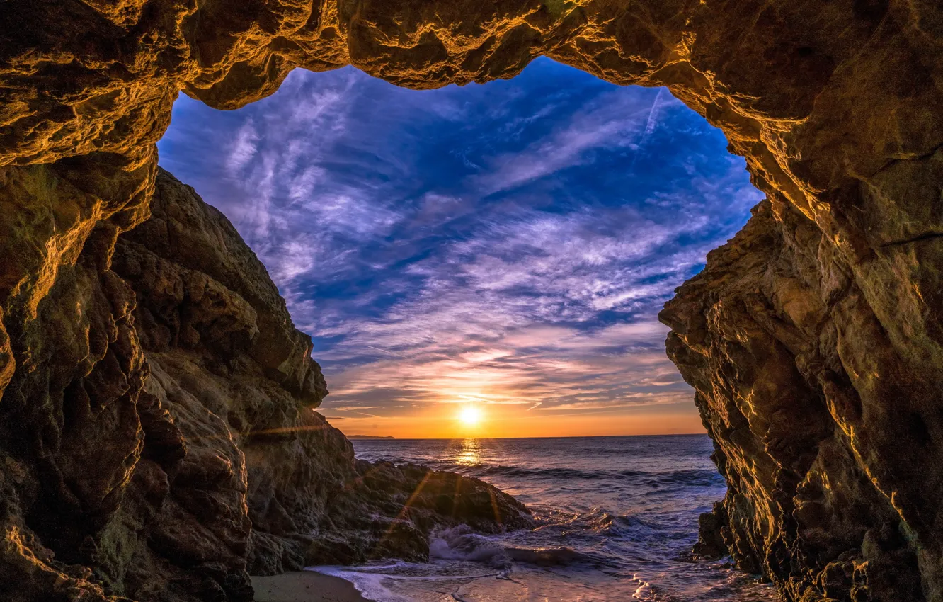 Фото обои море, небо, солнце, облака, лучи, закат, камни, скалы, берег, горизонт, арка, США, Malibu, Малибу